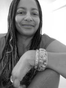 Woman smiling in an orange top wearing a bangle bracelet