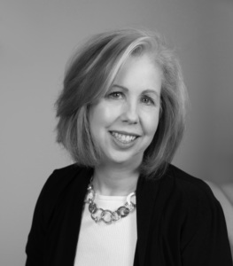 Headshot of a woman with mid-length hair in a blouse and blazer
