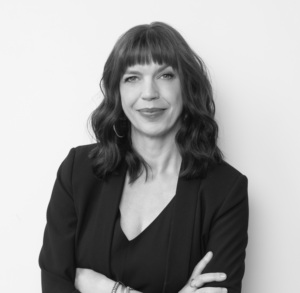 Headshot of a woman with bangs and arms crossed