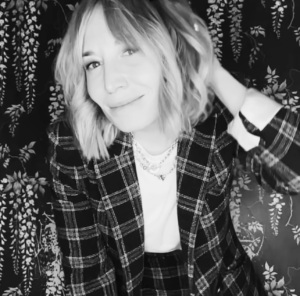Headshot of a woman in a plaid blazer and shoulder-length hair